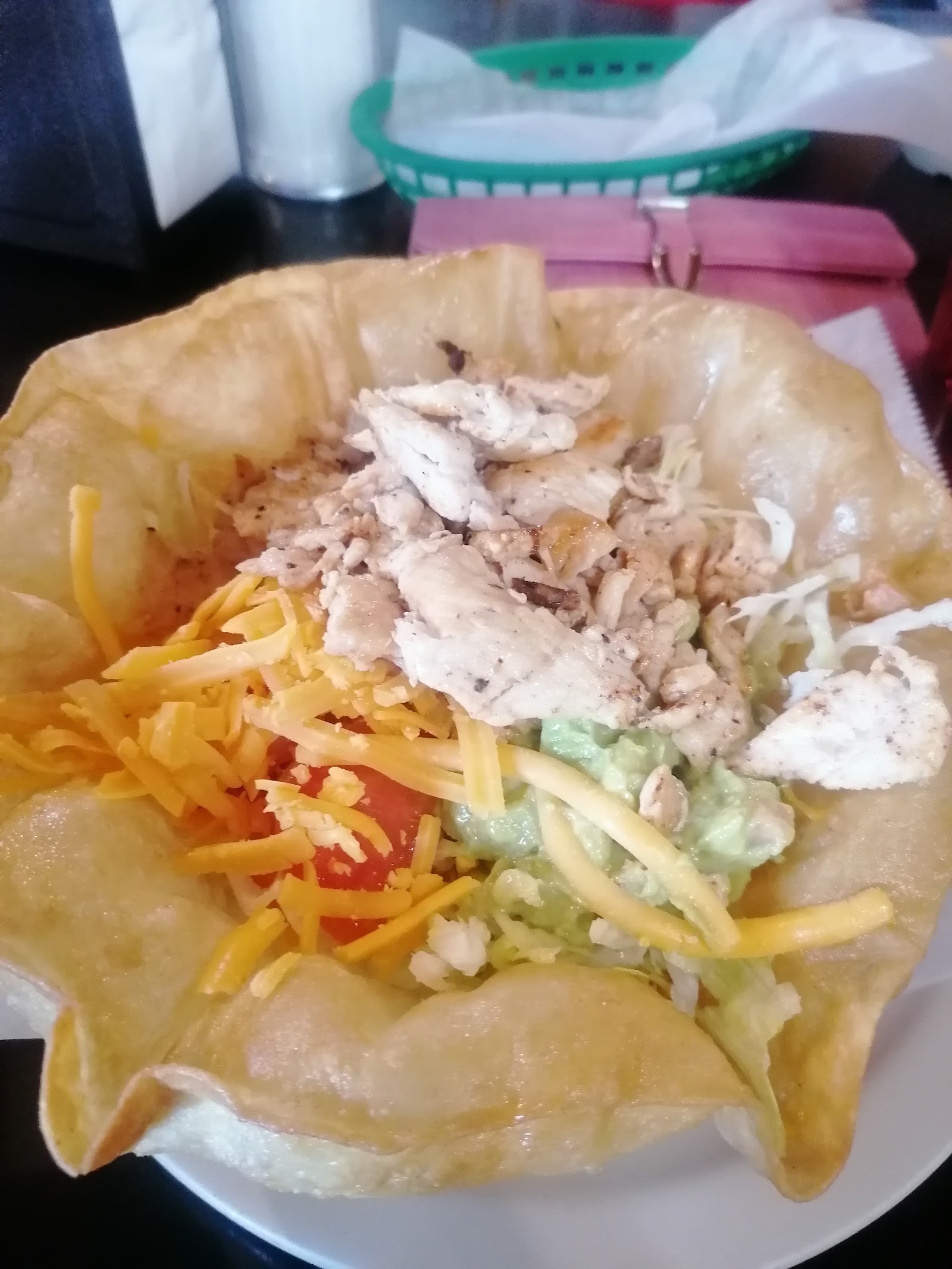 Crispy chicken taco salad with guacamole and cheddar cheese